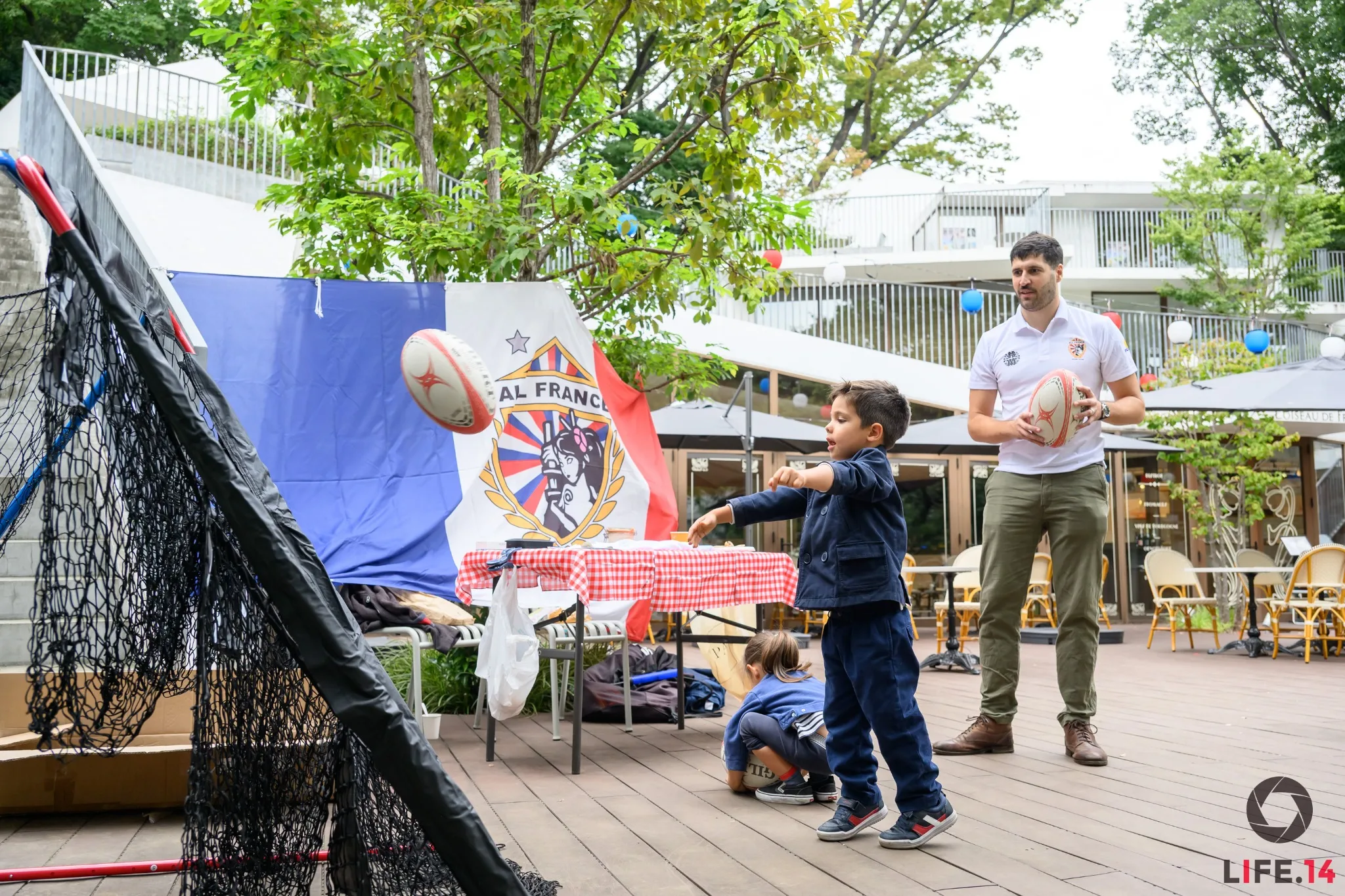A child throws a rugby ball toward the passing target at the AFRC stand during Vive l’Art de Vivre in Tokyo.